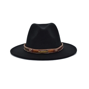 Detail of black wool fedora with brown suede band featuring a golden feather charm