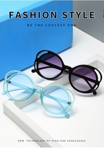 Detail of round oversized sunglasses featuring hollowed-out frames and gradient lenses