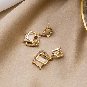 Square double-layered gold earrings with cat eye stone and pavé rhinestones on satin