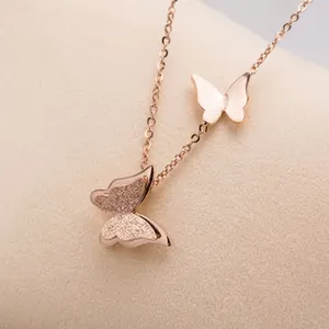 Detalle del collar con doble colgante de mariposa en oro rosa mate y pulido