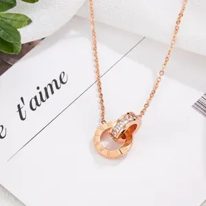 Dettaglio della collana in oro rosa con doppi anelli intrecciati e numeri romani incisi