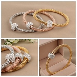 Detail of woven mesh bracelets in gold, silver, and rose gold with pavé crystal cylinder