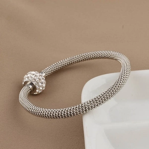 Macro shot of silver mesh bracelet featuring a sparkling rhinestone-encrusted slider bead
