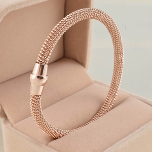 Rose gold mesh magnetic bracelet on beige velvet jewelry box with mirror polished finish