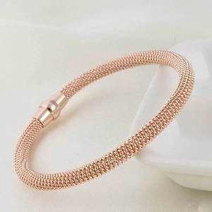 Close-up of rose gold mesh bracelet with magnetic clasp on a white ceramic tray