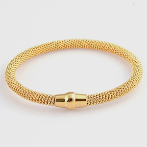 Detailed macro view of golden stainless steel mesh bracelet with magnetic cylinder clasp