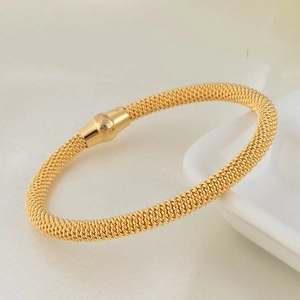 Detailed macro view of the gold braided mesh texture and magnetic clasp on stainless steel bangle
