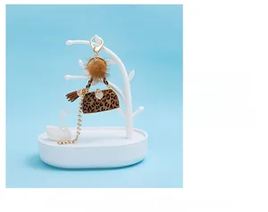 Detail of leopard print handbag keychain with brown faux fur pompom and heart charm