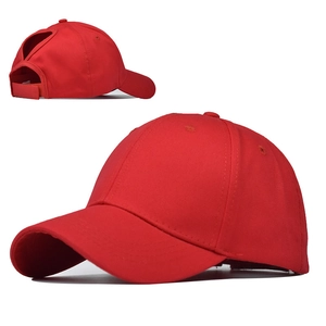 Detail view of red cotton baseball cap featuring a functional ponytail opening and velcro strap