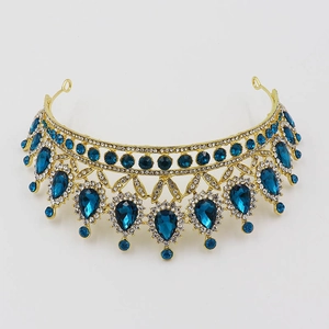 Macro view of gold baroque bridal crown with blue teardrop gems and clear rhinestones