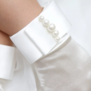 Dettaglio guanto in raso bianco con perle, elegante accessorio per polso da sposa