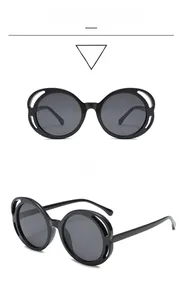 Detail of round sunglasses with black frames and unique curved hollow cut-outs