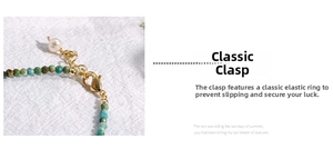Detail of turquoise faceted beads with a gold lobster clasp and a white pearl drop charm