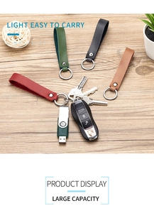 Genuine leather keychain set in four colors shown with keys and USB drive on wood background
