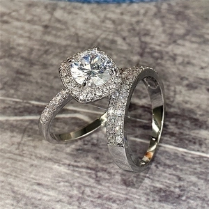 Macro shot of silver bridal ring set with halo round solitaire and paved wedding band