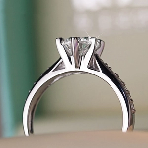 Classic six-prong zircon ring with side pavé stones on a polished silver-white band