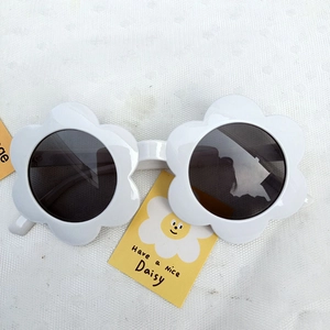 Close-up of kids flower shaped sunglasses with white frames and dark gray lenses