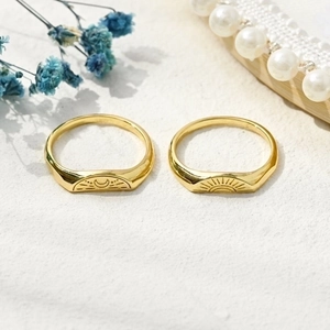 Minimalist 14k gold plated celestial sun and moon ring set on a white sand background