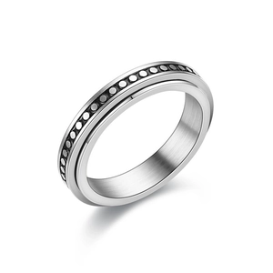 Macro detail of silver spinner ring featuring industrial style recessed dot geometric texture