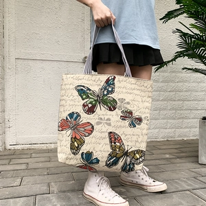 Close-up of colorful butterfly patterns and script print on canvas tote bag detail