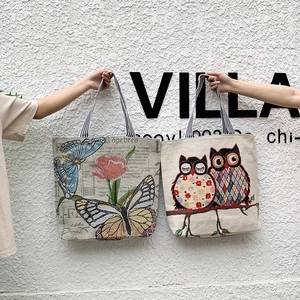 Detail of vintage canvas tote bags with butterfly and owl prints and striped straps