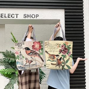 Detailed close-up of retro floral canvas tote bags with vintage bird prints and striped handles