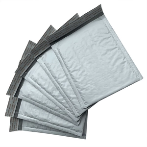 Stack of gray waterproof polyethylene bubble mailers for secure parcel shipping on white background