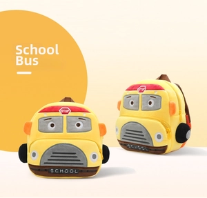 Detail of yellow school bus plush backpack with red stop sign and wheel embroidery