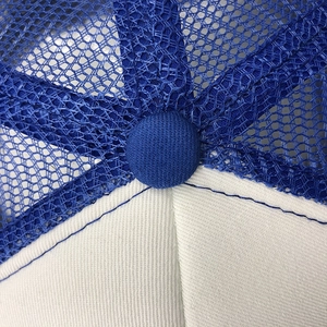 Macro detail of breathable blue mesh and white foam panels on a classic trucker hat
