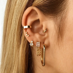 Detailed view of gold chain earrings with square zircon and textured metal ear cuffs