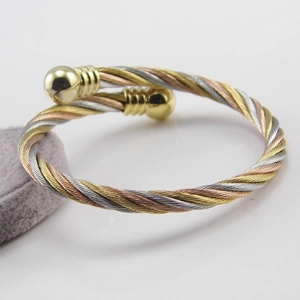 Detailed view of the three-tone twisted steel wire bracelet with gold ball end caps