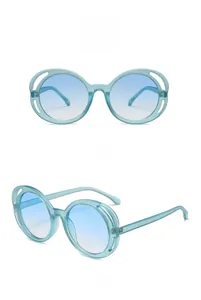 Close-up of matte sand blue round sunglasses with gradient lenses and hollow frame