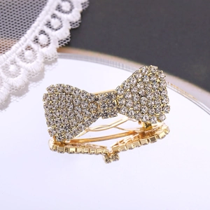 Close-up of sparkling rhinestone bow hair clip on mirror with lace background