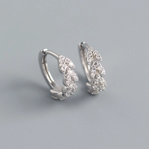 Macro detail of leaf-shaped S925 sterling silver earrings with sparkling pavé crystals
