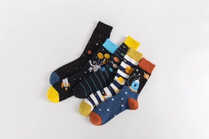 Flat lay view of five colorful cotton mid-calf socks with space exploration patterns