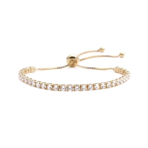 Detailed macro view of the adjustable bolo clasp on a gold tennis bracelet with zircons