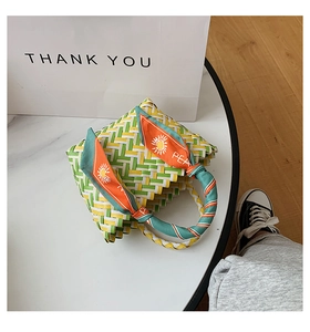 Close-up of woven straw handbag featuring yellow green checkerboard pattern and silk scarf