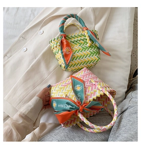 Detail of woven straw tote bags with checkered pattern and colorful decorative scarves