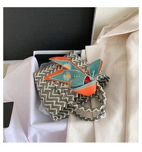 Top view of woven tote bag with geometric pattern and floral silk scarf detail