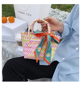 Close-up of woven pink yellow white summer basket bag with daisy print scarf detail