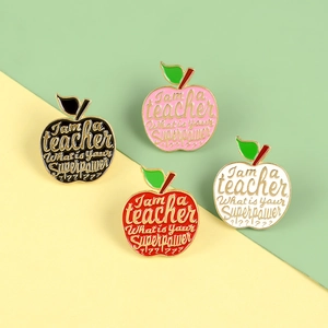 Détail de quatre broches pommes colorées en émail pour enseignants avec texte