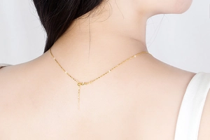 Detail of adjustable golden S925 silver star necklace on woman's neck for elegant styling