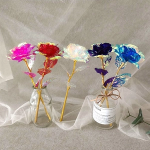 Detailed view of artificial holographic roses in multiple colors with golden stems in glass vase