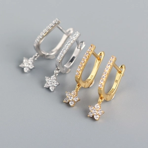 Macro detail of U-shaped S925 silver earrings with pavé crystals and flower charm