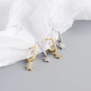Macro shot of gold and silver S925 sterling silver U-shaped earrings with star charms