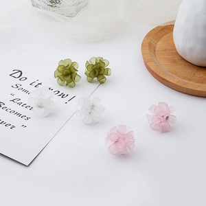 Macro detail of matte frosted petal earrings in white, green and pink floral styles
