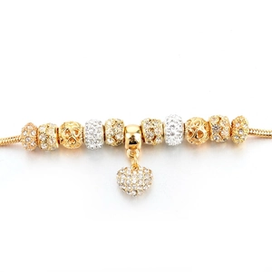 Detailed macro view of gold-plated snake chain with sparkling rhinestone heart pendant