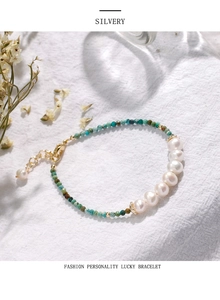 Detail showing freshwater pearls and green turquoise beads on a gold-plated bracelet