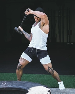 Close-up of men's two-in-one sports shorts with white tank top in a fitness gym setting