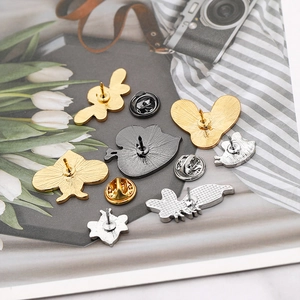 Detail of bee brooch backs showing metal butterfly pin clasps and various gold finishes